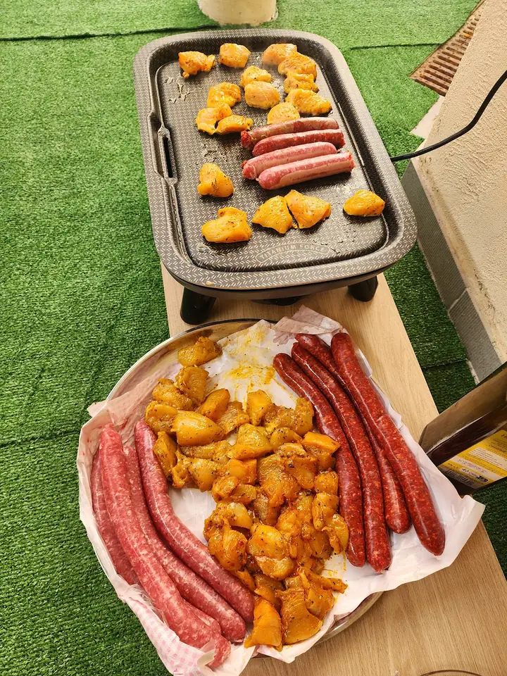 Merguez et poulet mariné sur une plaque de cuisson